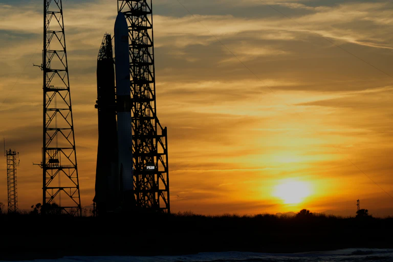 A rocket at a launchpad with the sunset in the background.