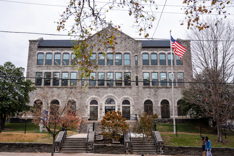 Exterior of large stone building with stately steps and lawn