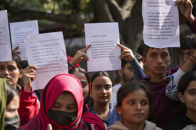 La militarización en Jammu y Cachemira afecta negativamente a la educación de las mujeres 1 Jóvenes sosteniendo pancartas entre la multitud.