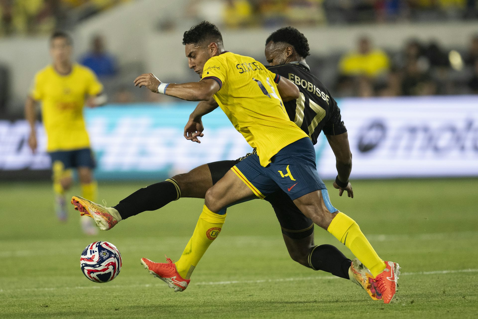 Dos futbolistas compiten por el balón.