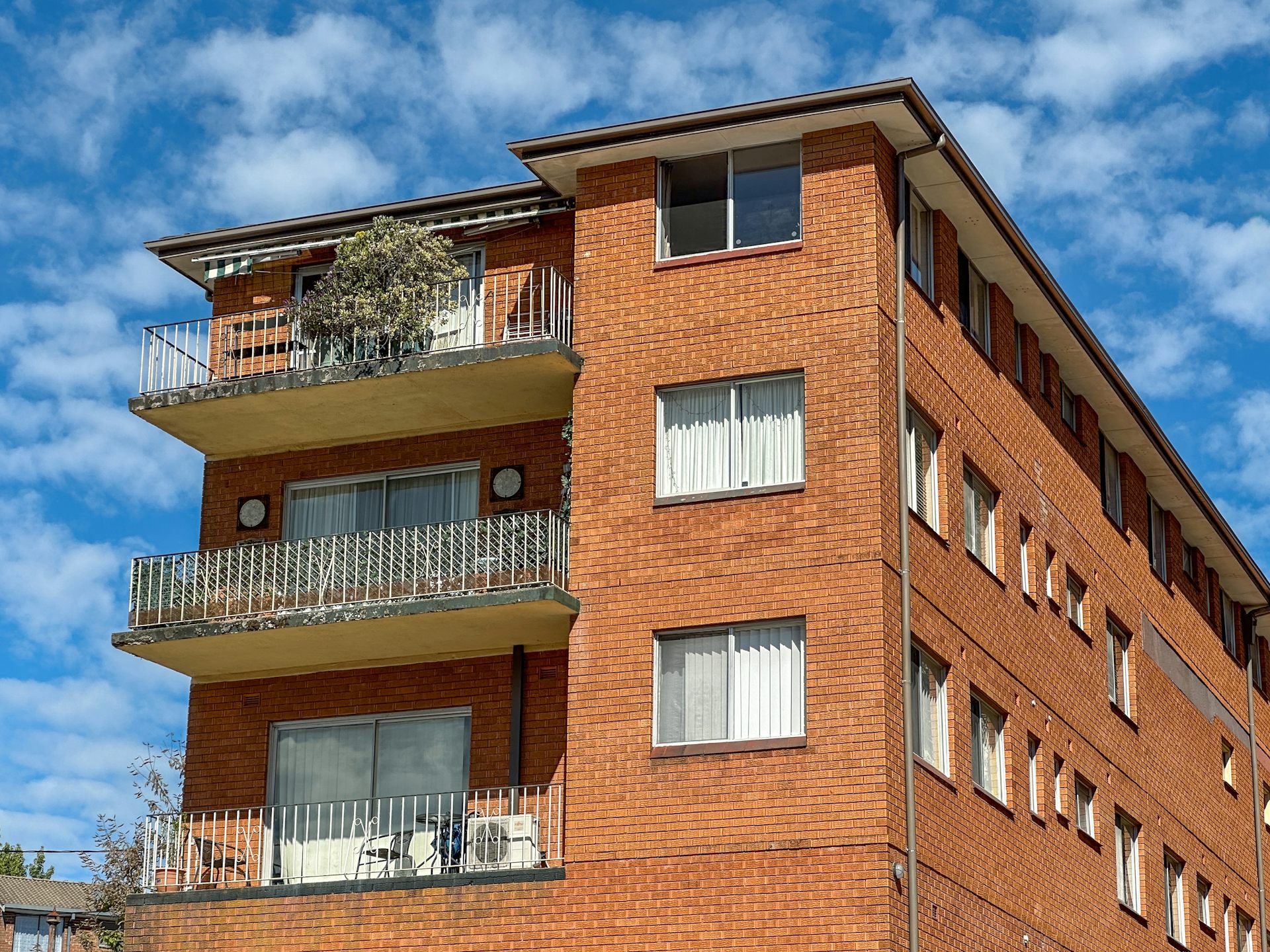 red brick apartment block in sunshine.