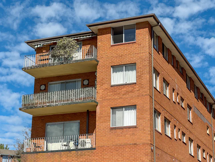 red brick apartment block in sunshine.