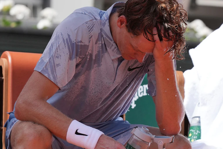 Jannik Sinner pours water over his head trying to stay cool during the French Open.