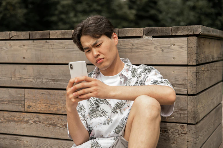 A man looking displeased at his phone.