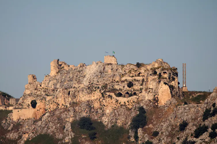 An old castle fortification stands atop a hill.
