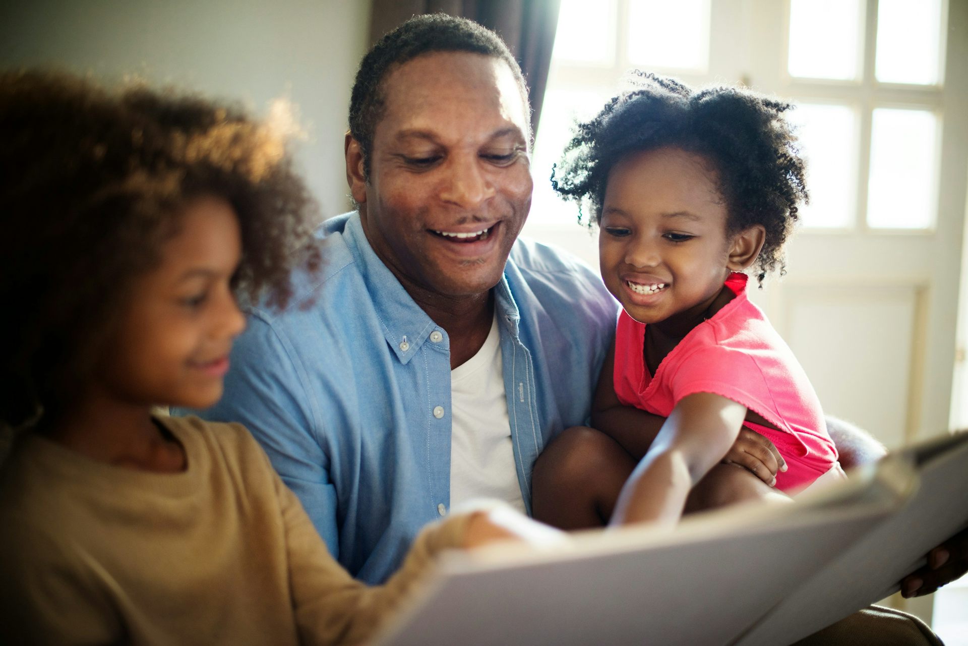 A father and children sitting reading a book