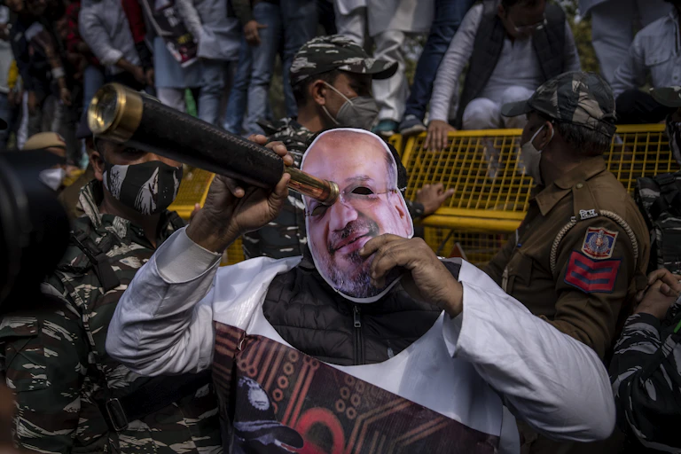 A protester wearing a mask of Amit Shah, India's home minister, looks through a scope during a rally accusing Prime Minister Narendra Modi's government of using military-grade spyware to monitor political opponents, journalists and activists.