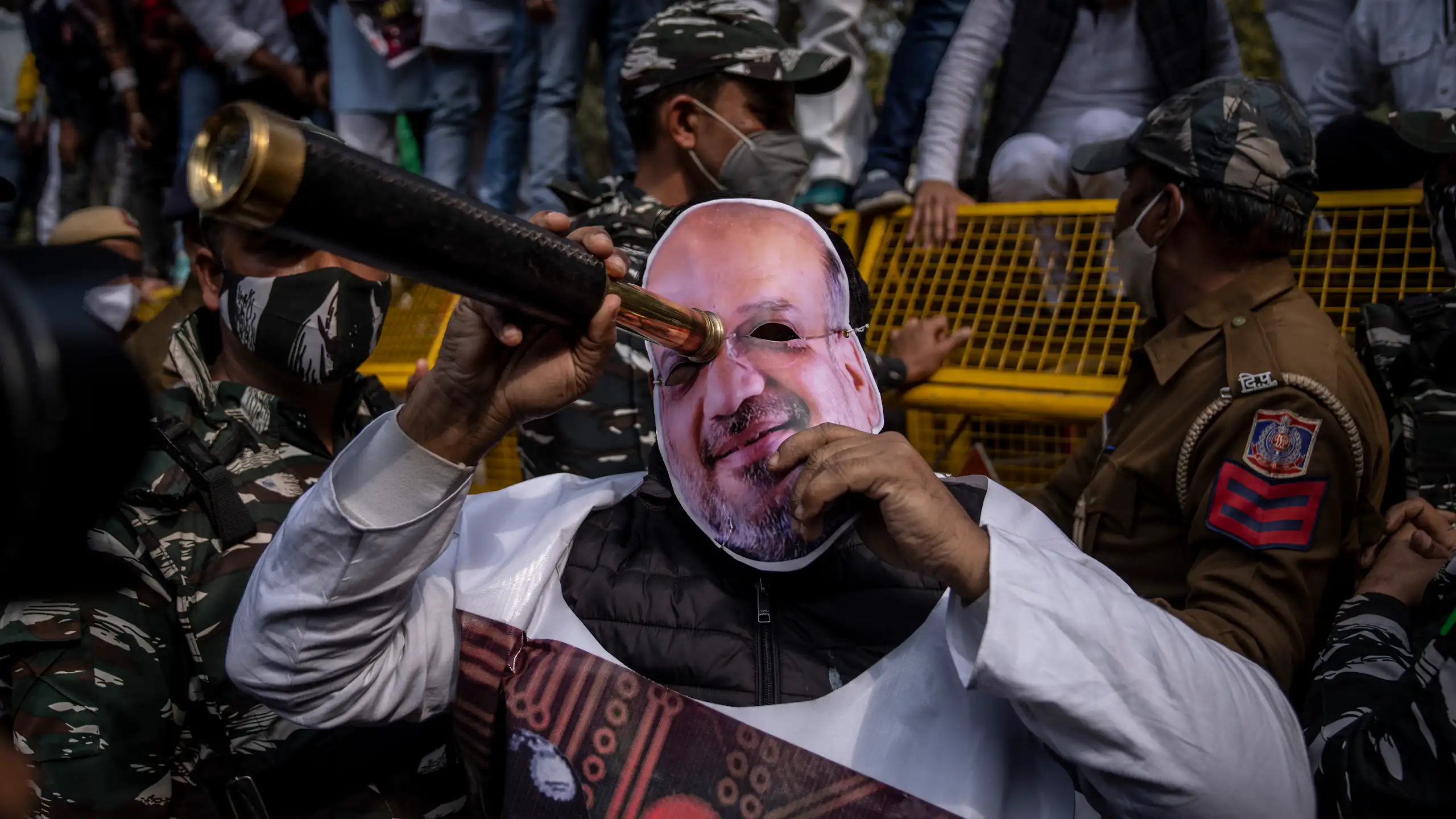 A protester wearing a mask of Amit Shah, India's home minister, looks through a scope during a rally accusing Prime Minister Narendra Modi's government of using military-grade spyware to monitor political opponents, journalists and activists.