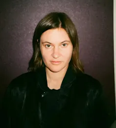 a young woman with dark hair, dressed in black