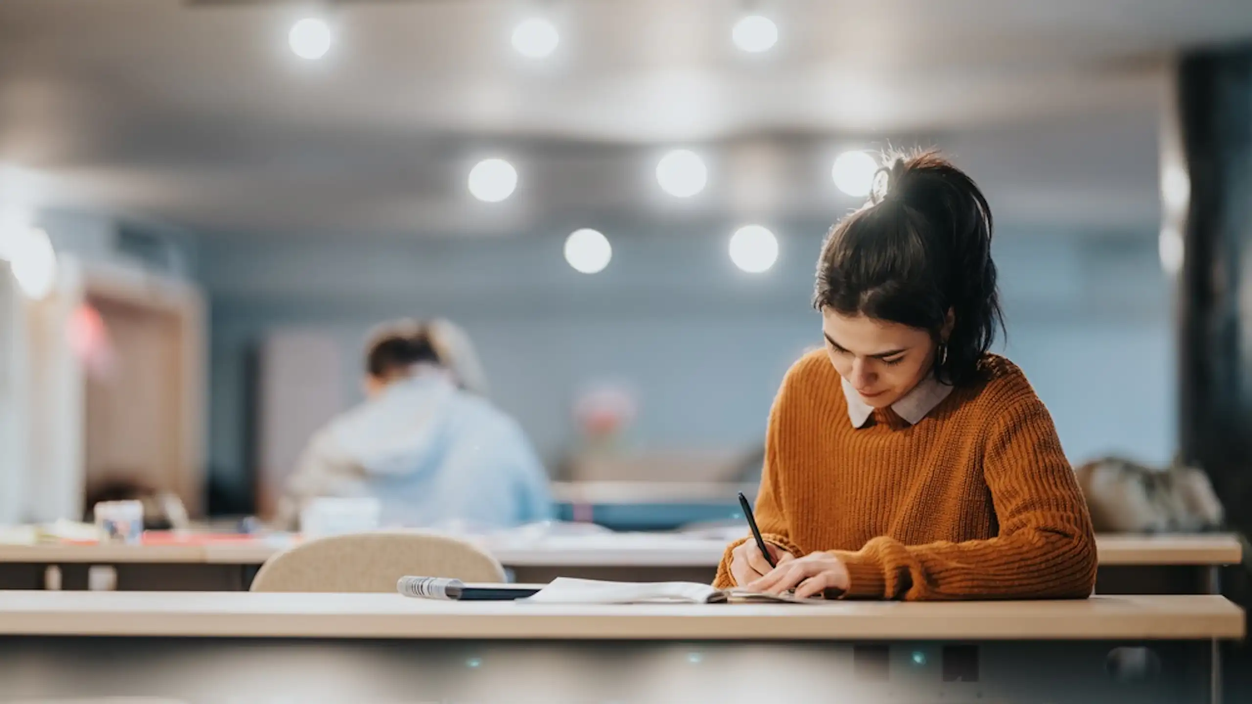 Une jeune femme qui révise dans une salle de classe.