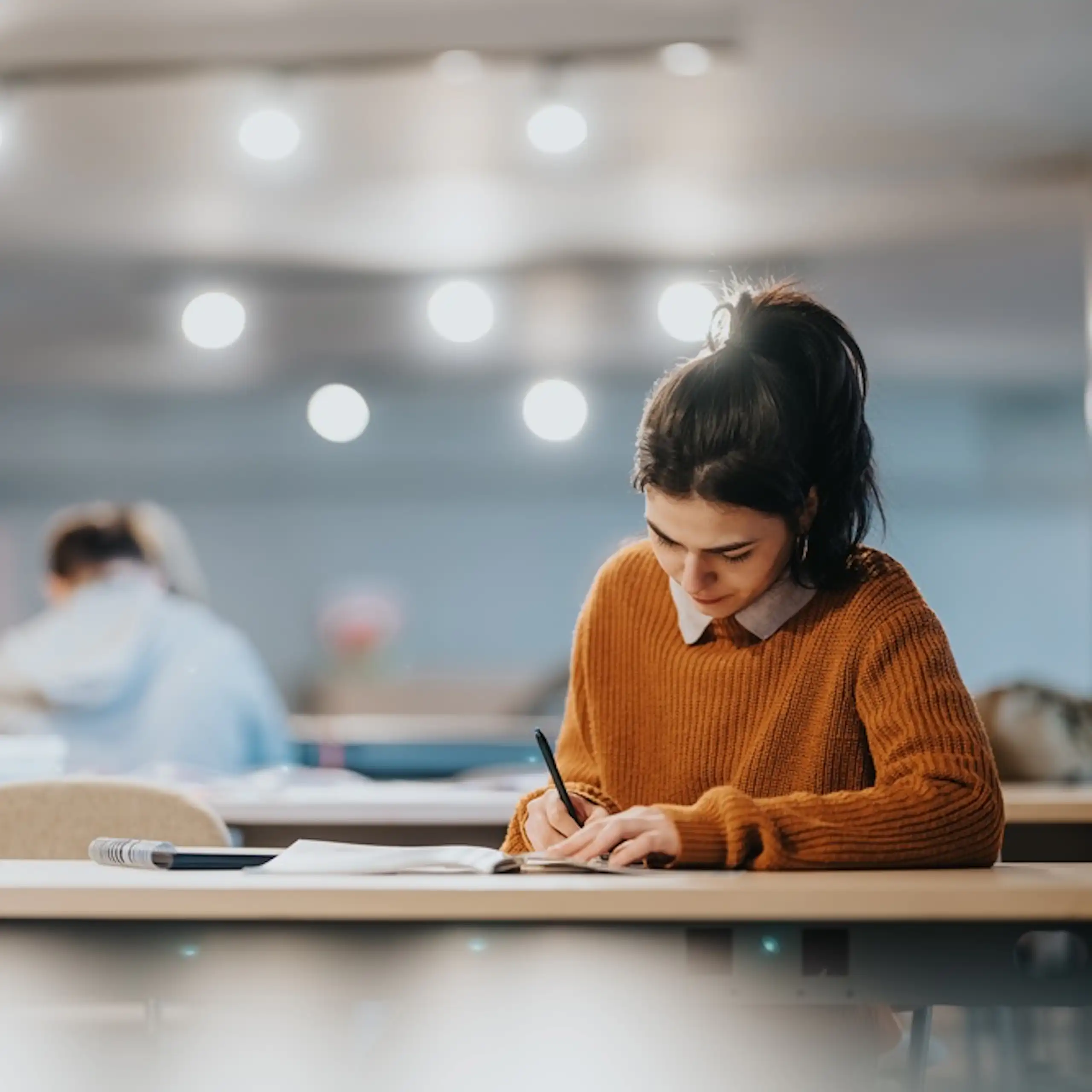 Une jeune femme qui révise dans une salle de classe.