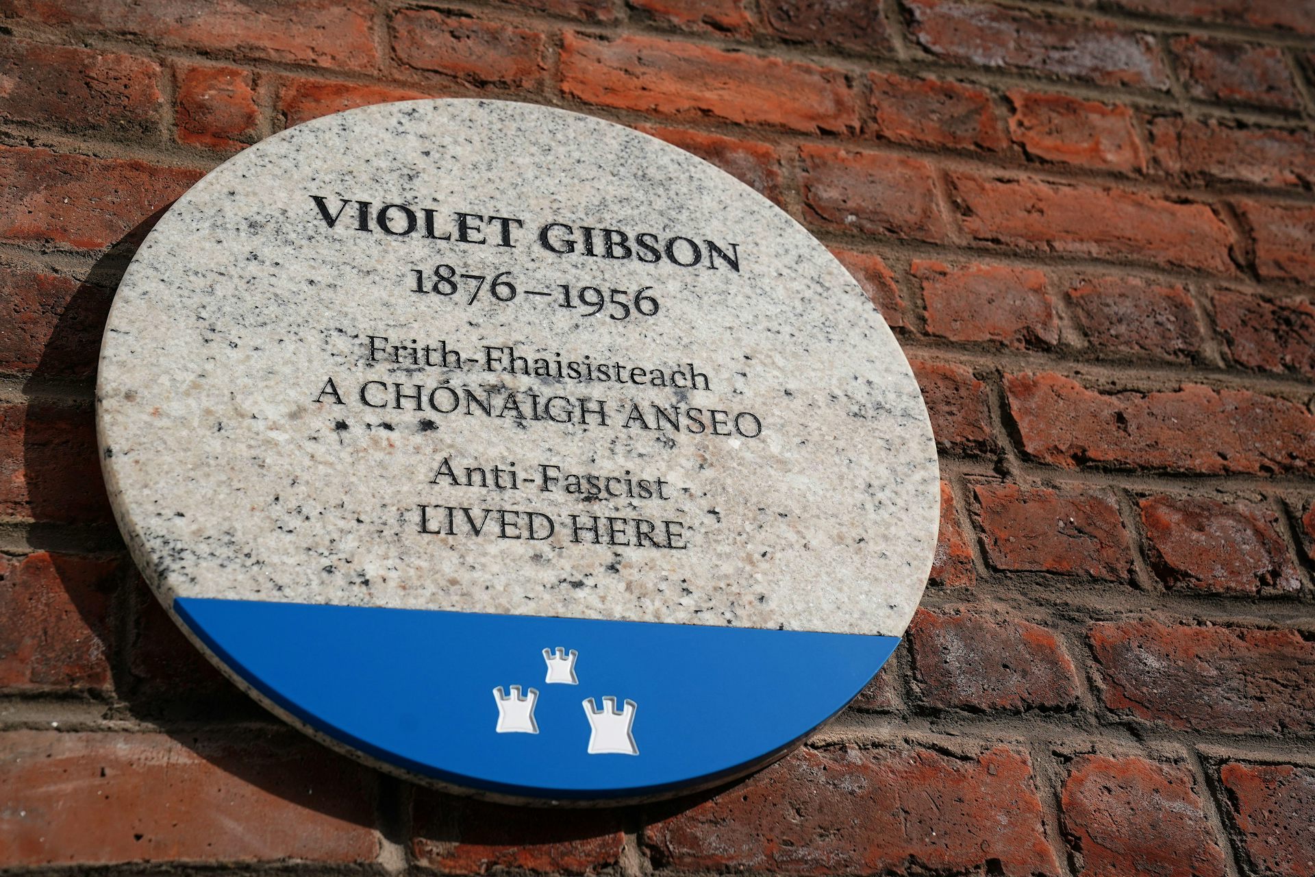 Marble plaque on a brick wall.