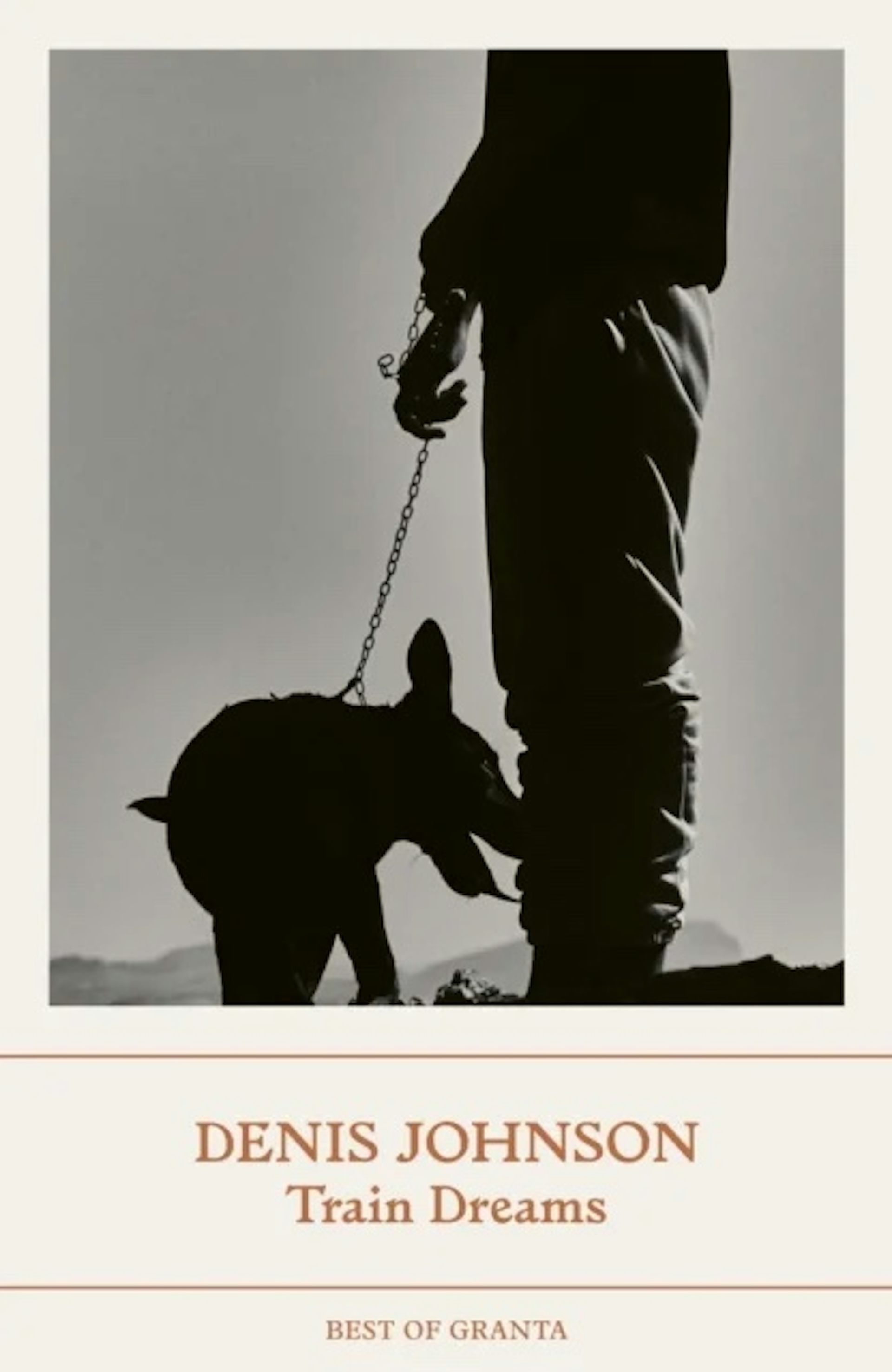 The cover for Train Dreams, showing a man holding the leash of a dog