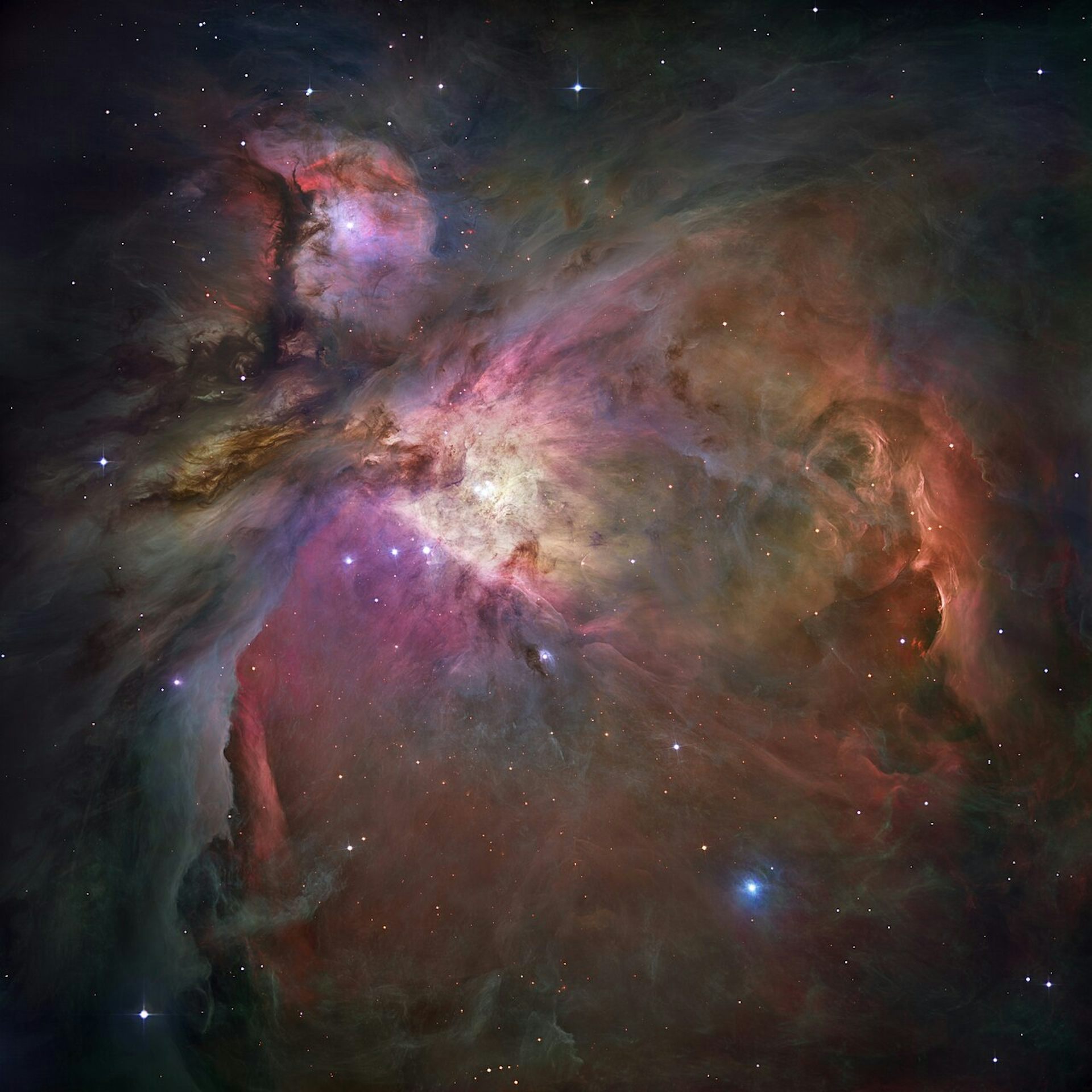 The Orion Nebula with pink and purple gas and brown dust.
