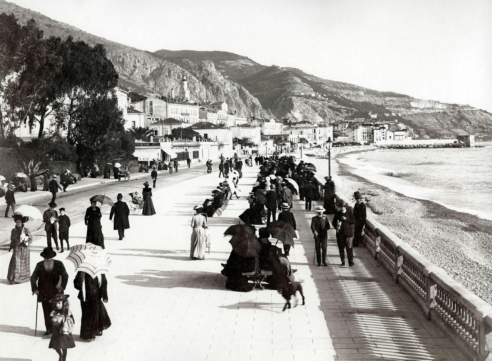 A vintage photograph of tourists strolling the promenade in Menton