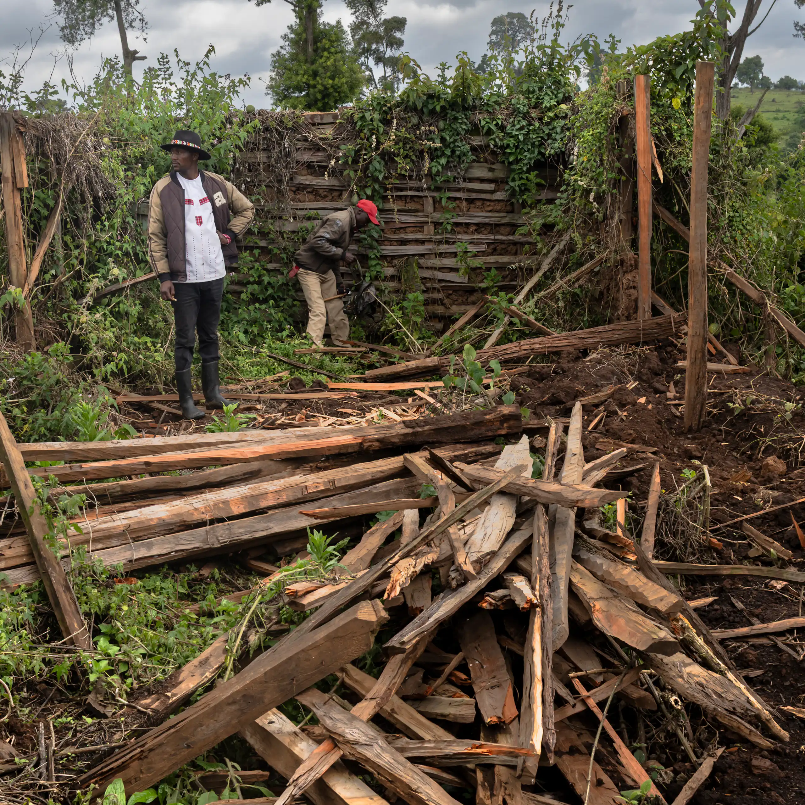 Two people pick through debris left from the destruction of a home.