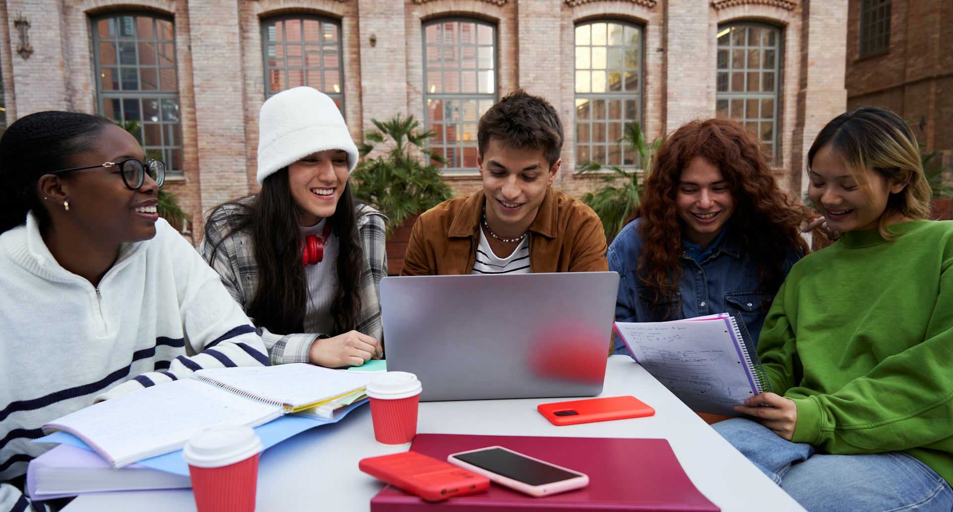 Jovens sorridentes reunidos em torno de um computador