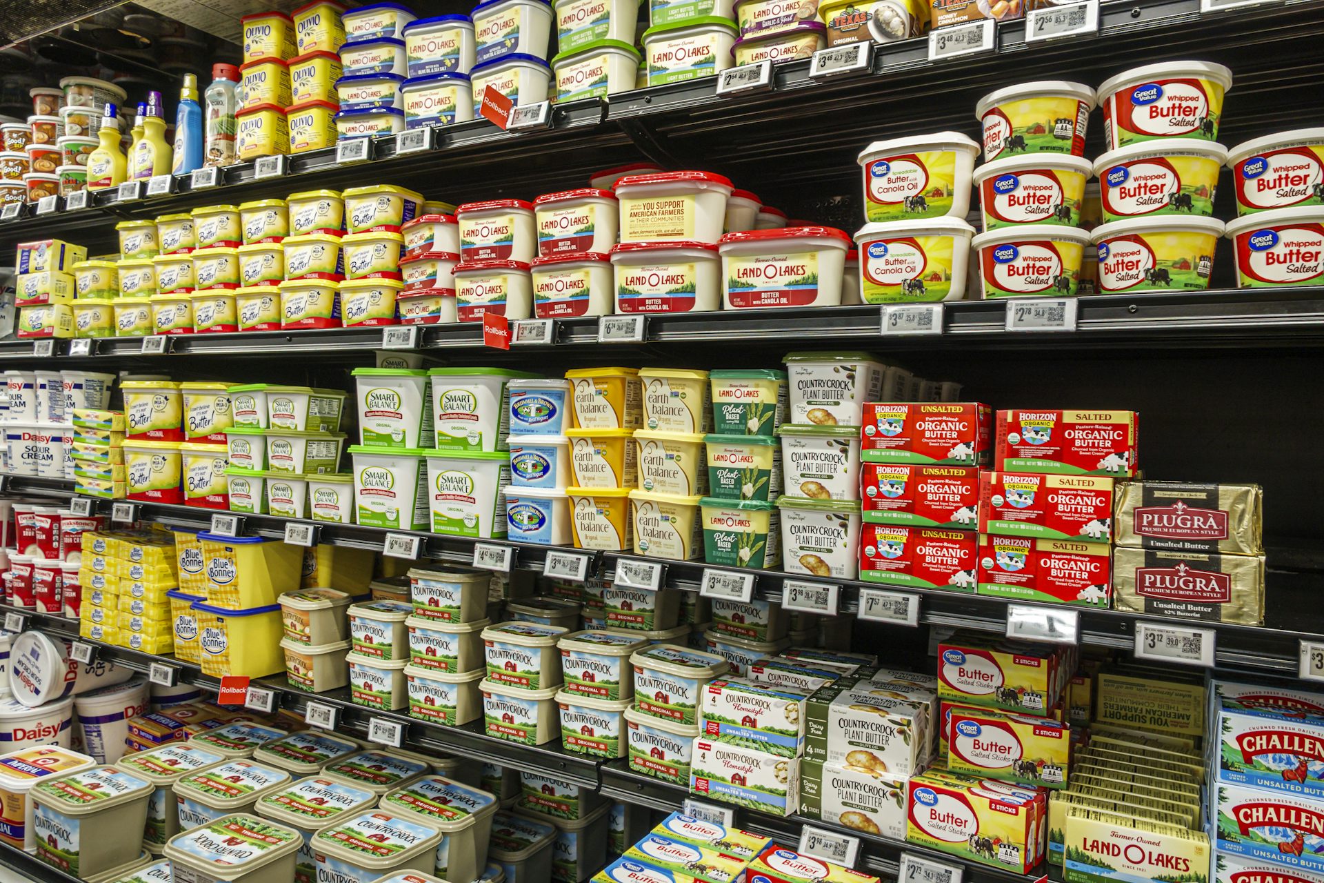Grocery store shelves stocked with tubs of butter and margarine