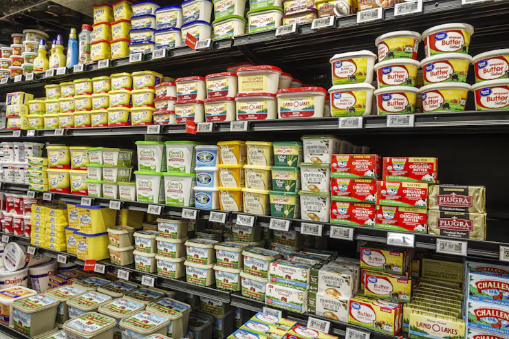 Grocery store shelves stocked with tubs of butter and margarine