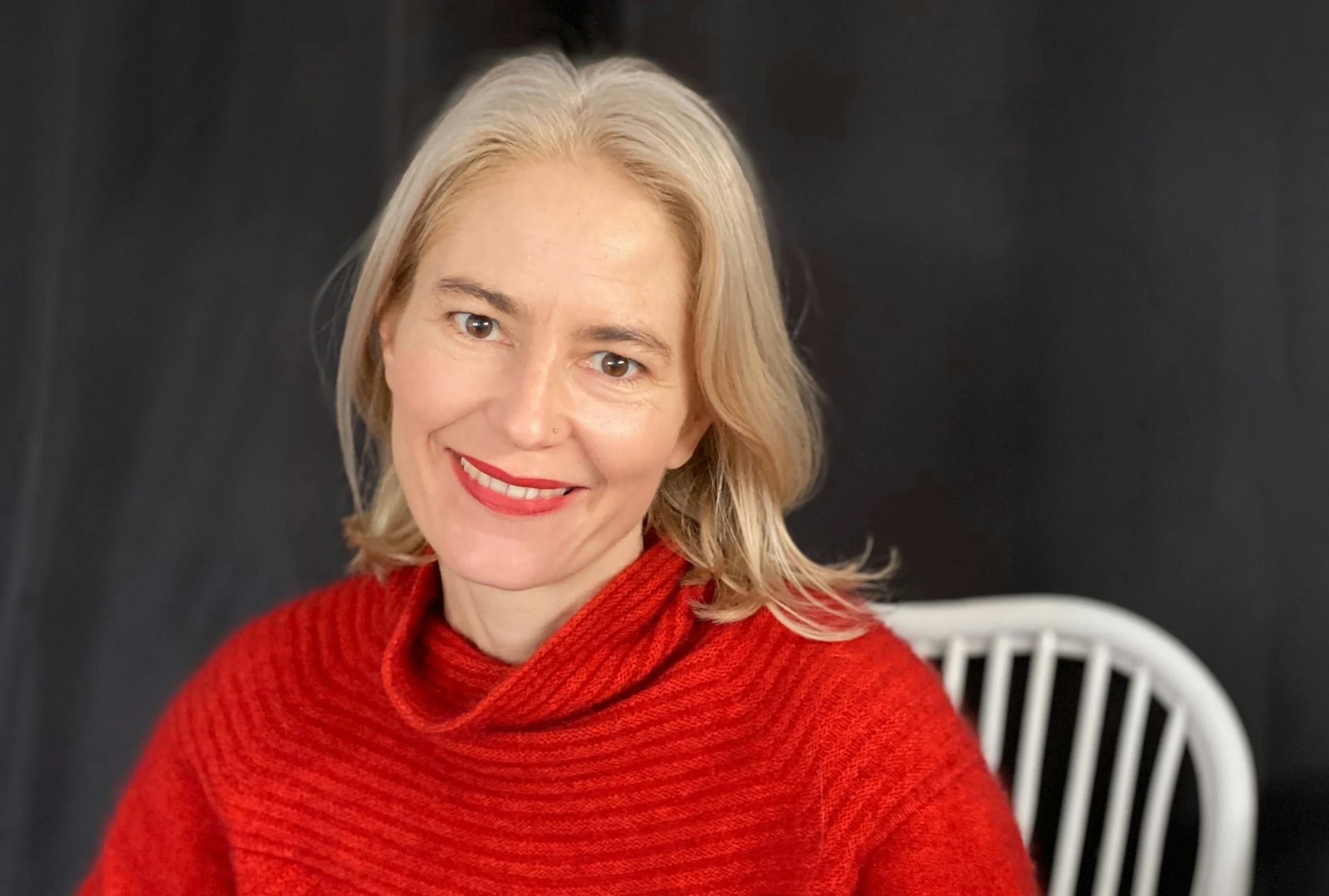 Photograph of Shady Cosgrove wearing a red jumper and smiling.