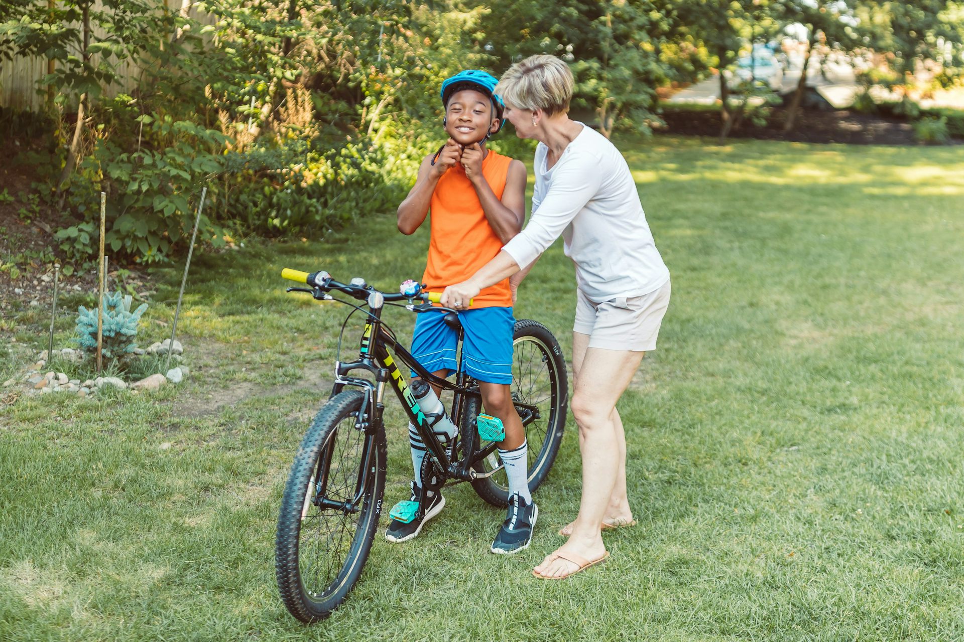 A woman helping a child ride a bike