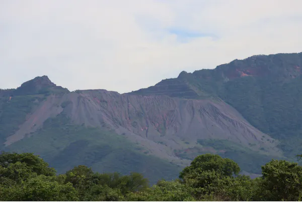 A range of mountains in the distance, landmark features cut into them in rows.