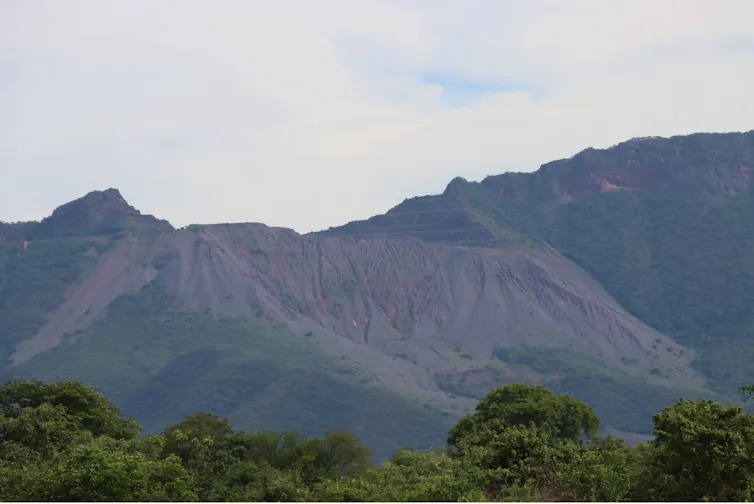 A range of mountains in the distance, landmark features cut into them in rows.