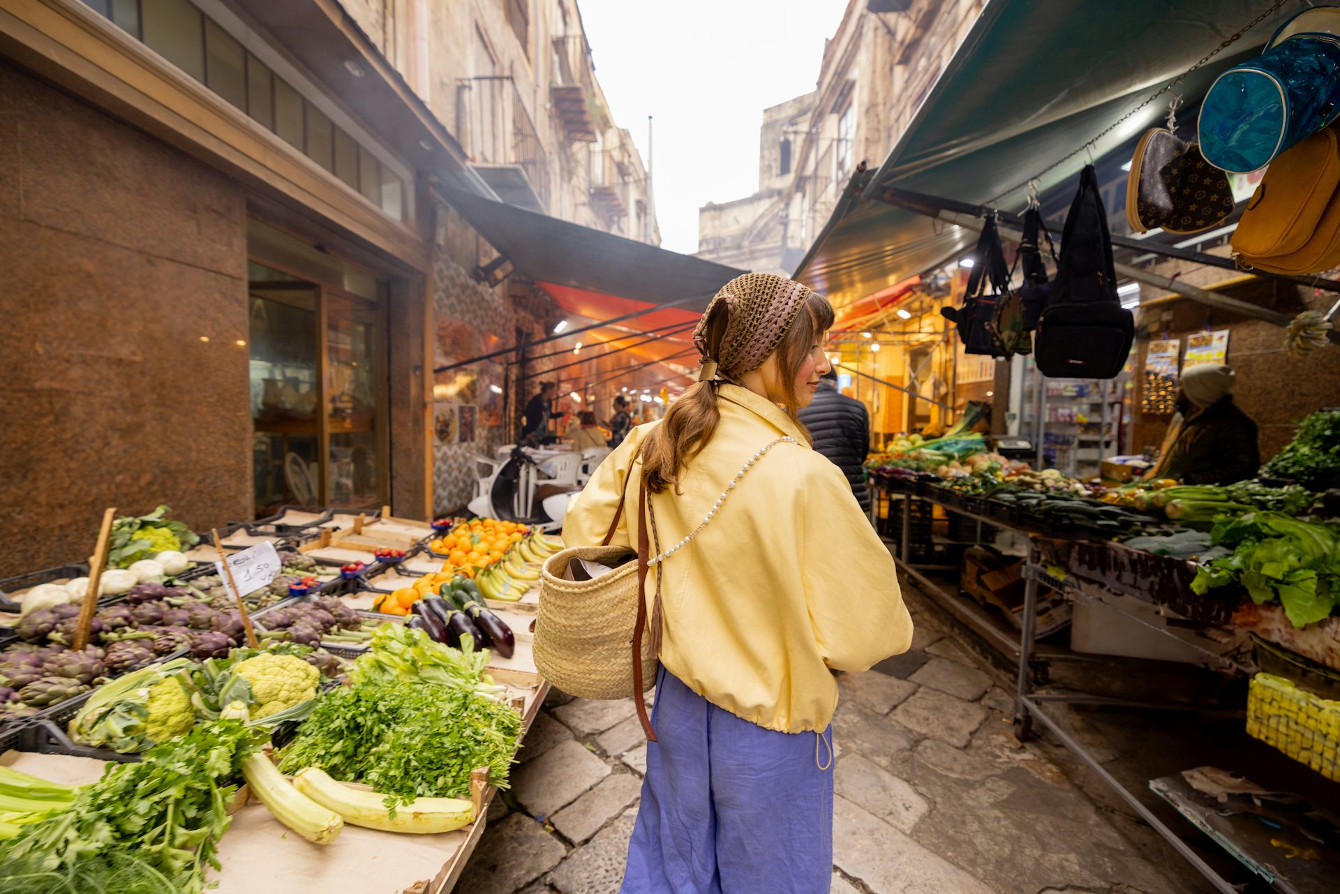 Una xica passeja per un mercat al carrer.