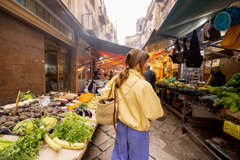 Una xica passeja per un mercat al carrer.
