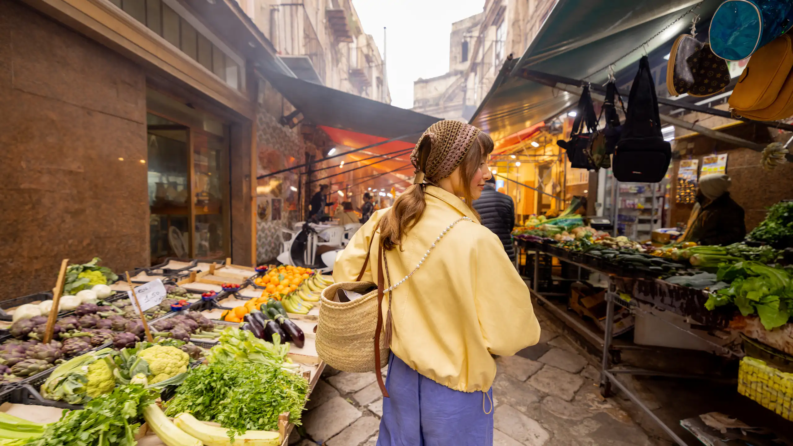 Una xica passeja per un mercat al carrer.