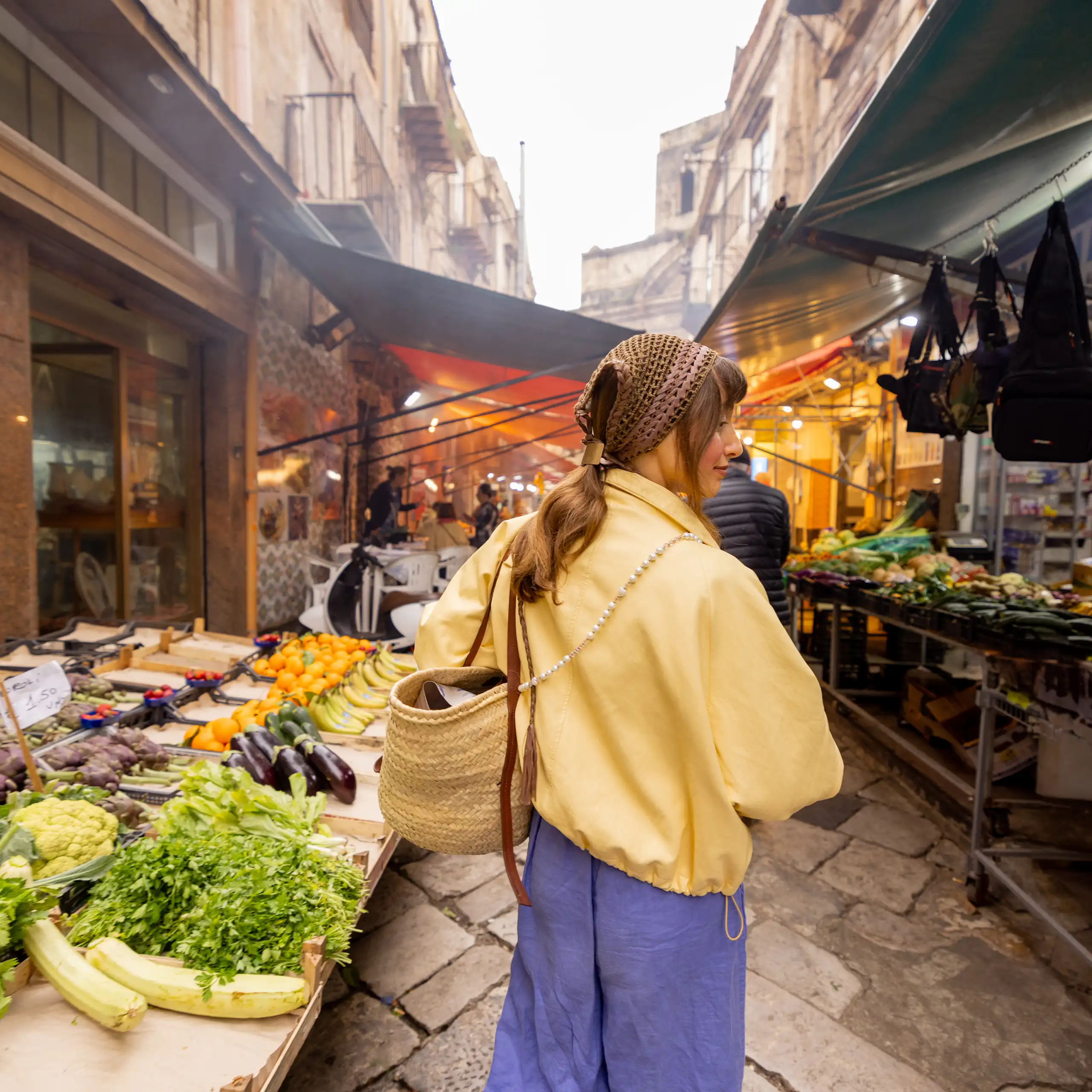 Una xica passeja per un mercat al carrer.