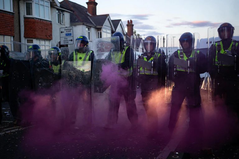 Flares erupt around police with riot shields