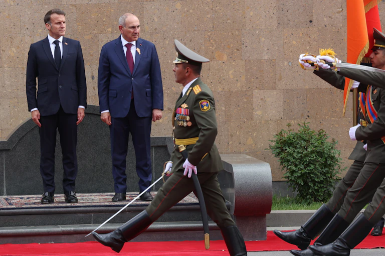 Nikol Pashinyan and Emmanuel Macron observe a military guard at a ceremony in Yerevan.