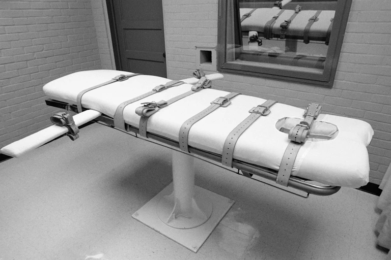 A black and white photo of a gurney in a death chamber.