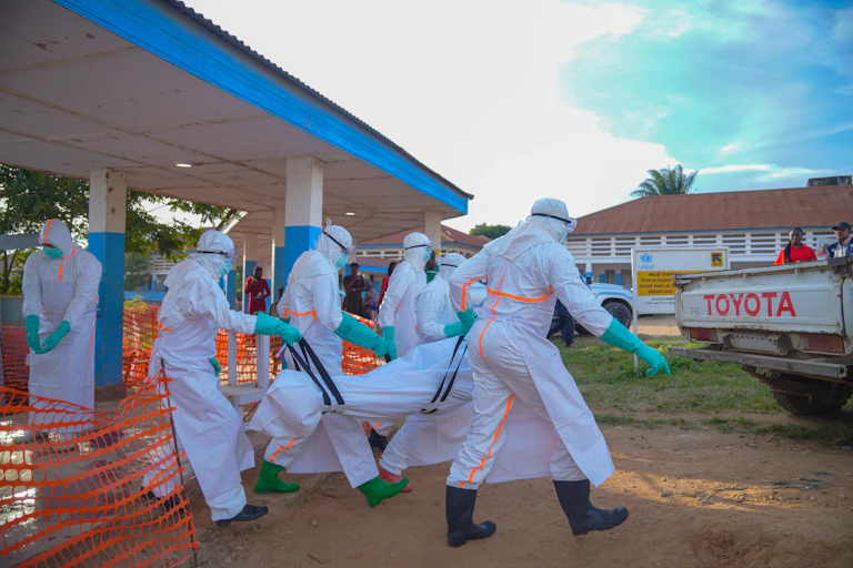 Medical staff wearing protective equipment handle the body of an Ebola victim in a body bag at Bunia General Hospital in Bunia, Ituri Province, Democratic Republic of the Congo