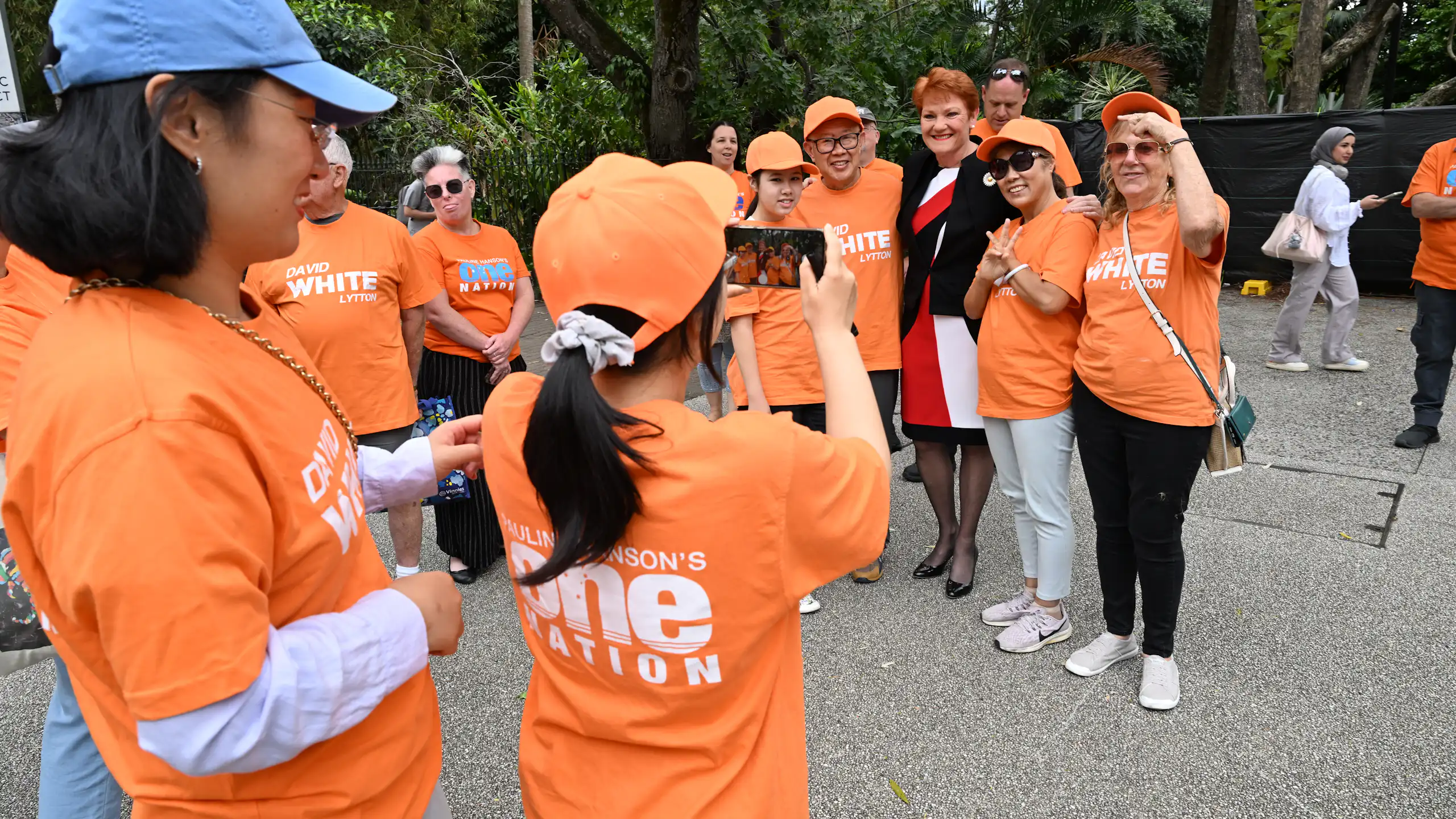 One Nation supporters in orange t-shirts pose for a photo with Pauline Hanson