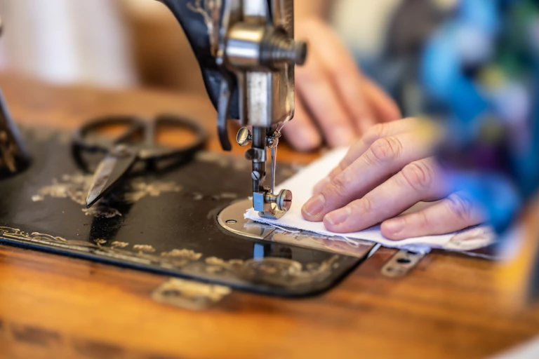 A close up of a woman sewing on a machine
