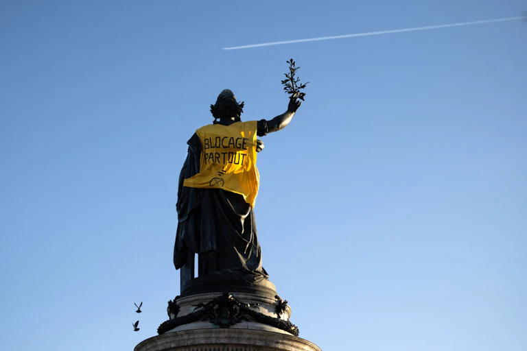 La statue de la Place de la République à Paris revêtue d'un gilet jaune sur lequel est inscrit le slogan : « Blocage partout ! »