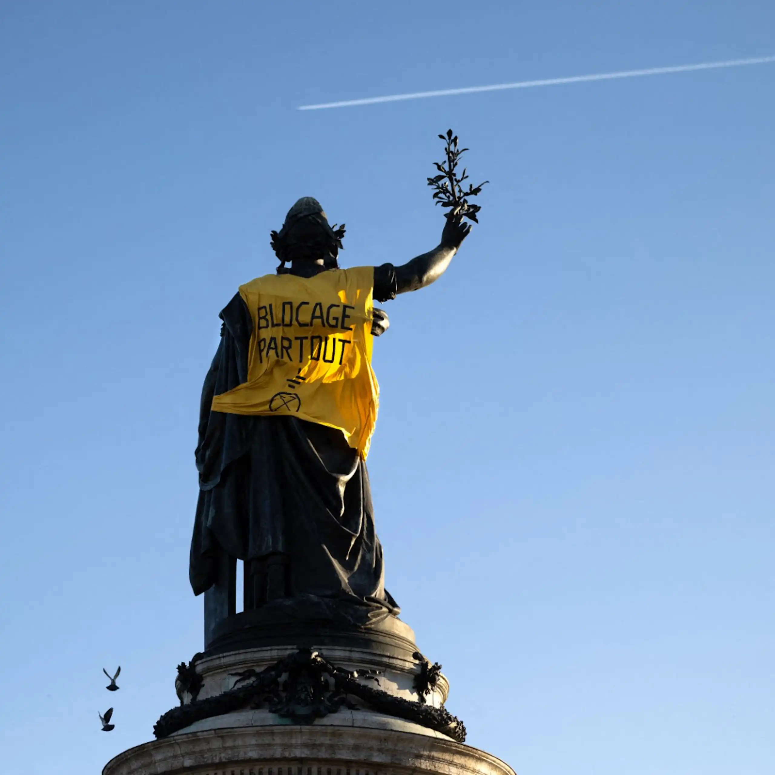 La statue de la Place de la République à Paris revêtue d'un gilet jaune sur lequel est inscrit le slogan : « Blocage partout ! »