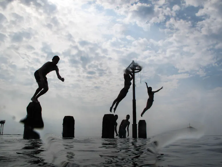 Young people jumping into sea