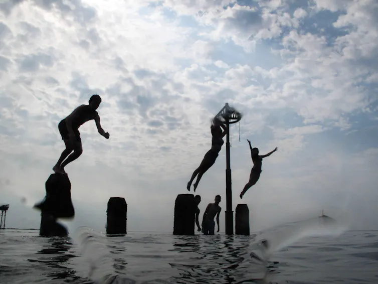 Young people jumping into sea