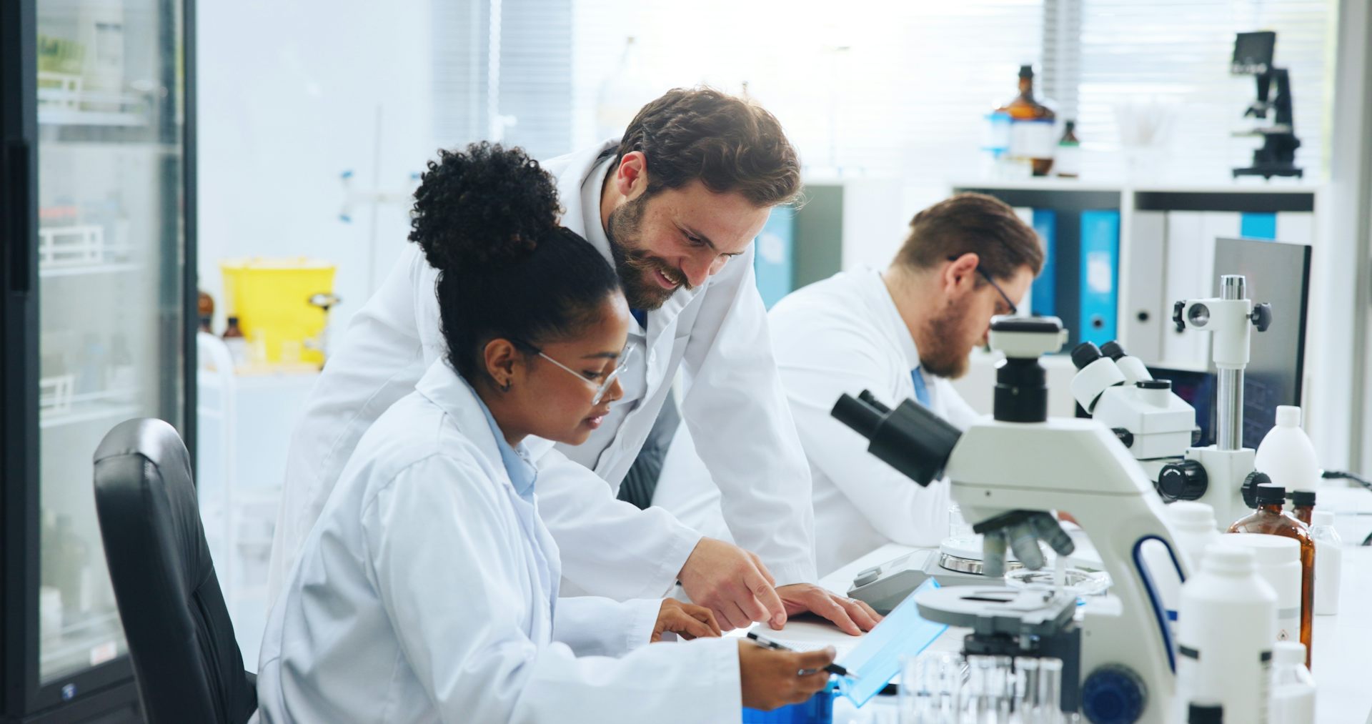 Deux chercheurs dans un laboratoire de recherche regardent au microscope.