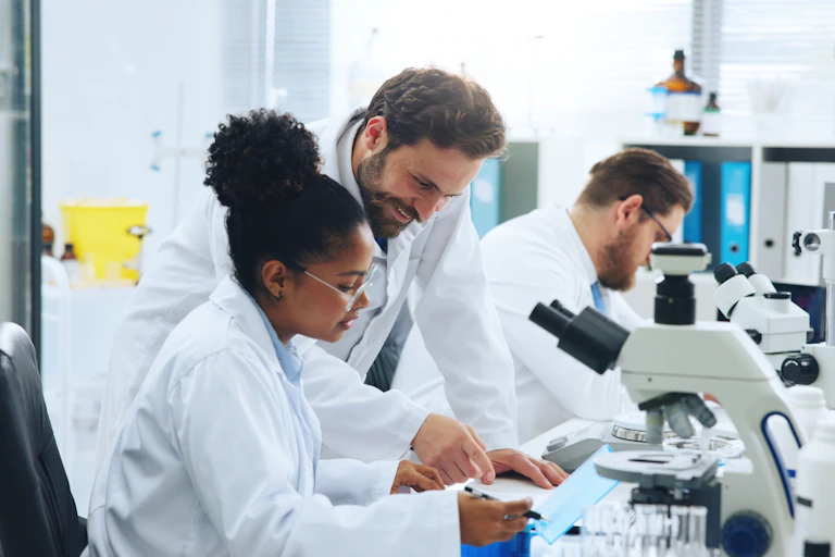 Deux chercheurs dans un laboratoire de recherche regardent au microscope.