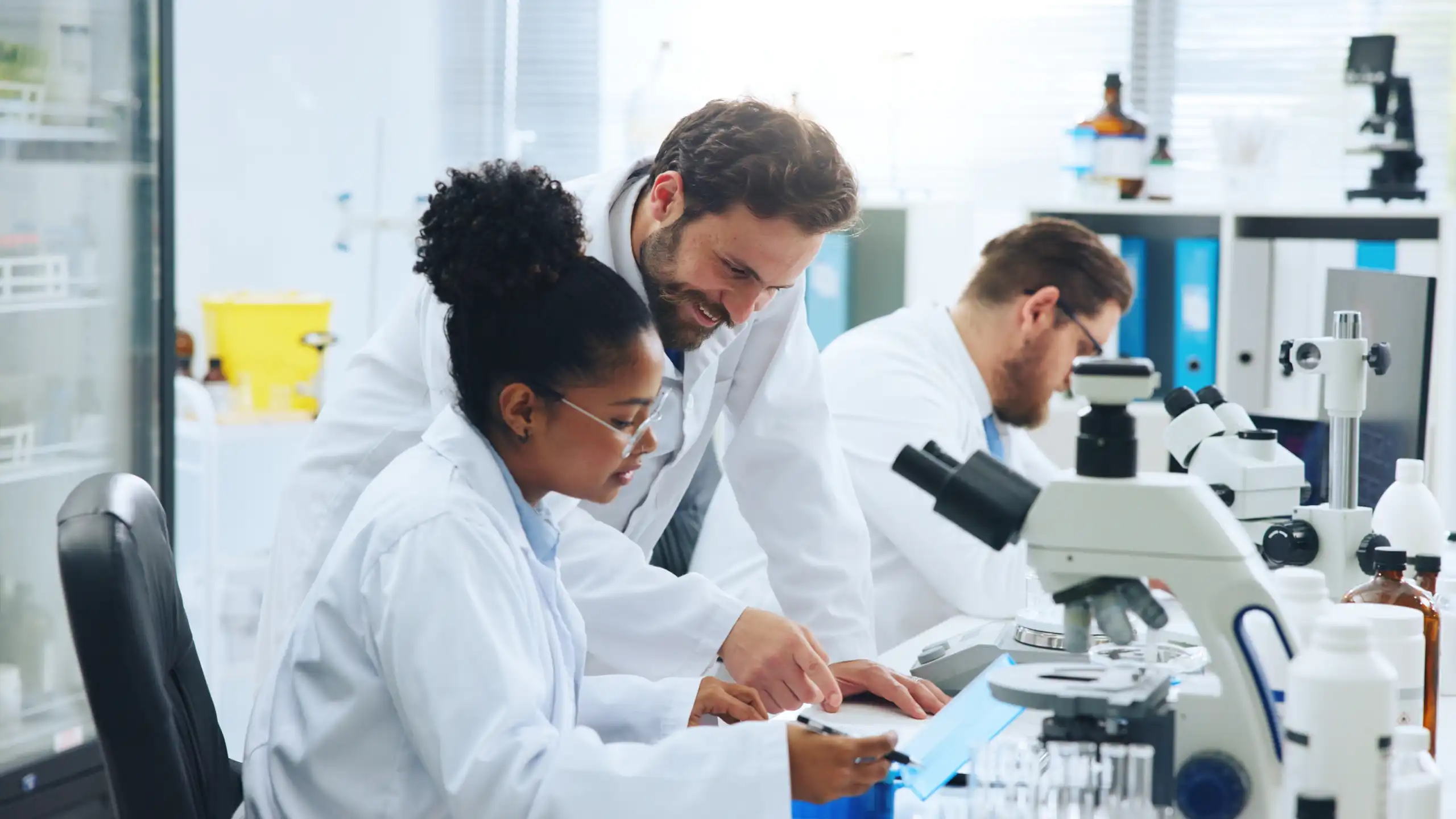 Deux chercheurs dans un laboratoire de recherche regardent au microscope.