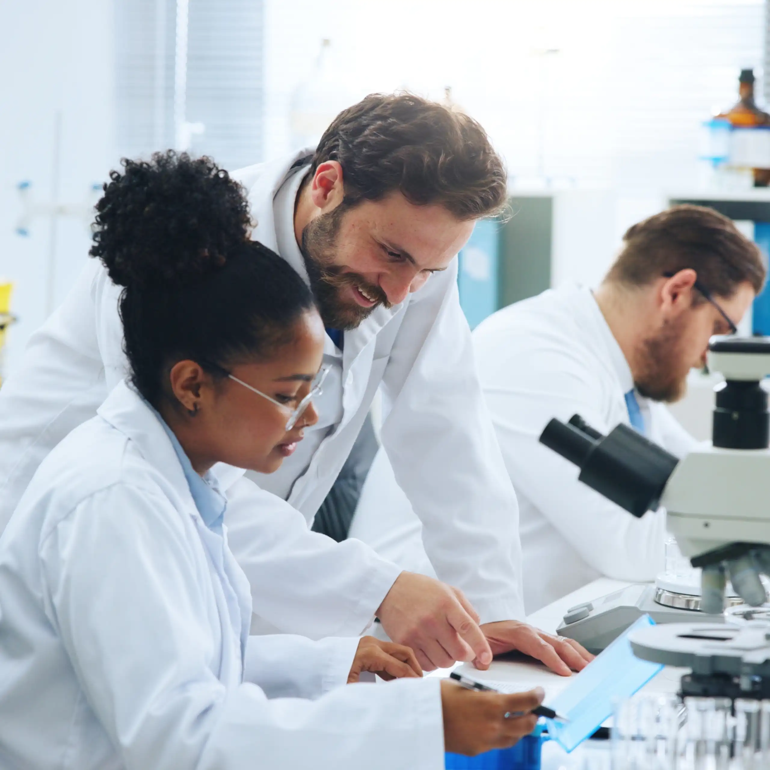 Deux chercheurs dans un laboratoire de recherche regardent au microscope.