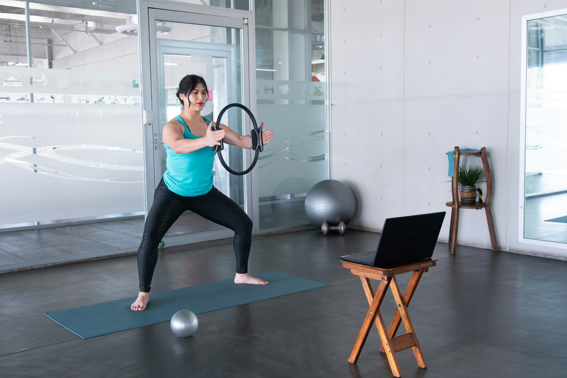 Une femme pratiquant des exercices de gym devant son ordi.