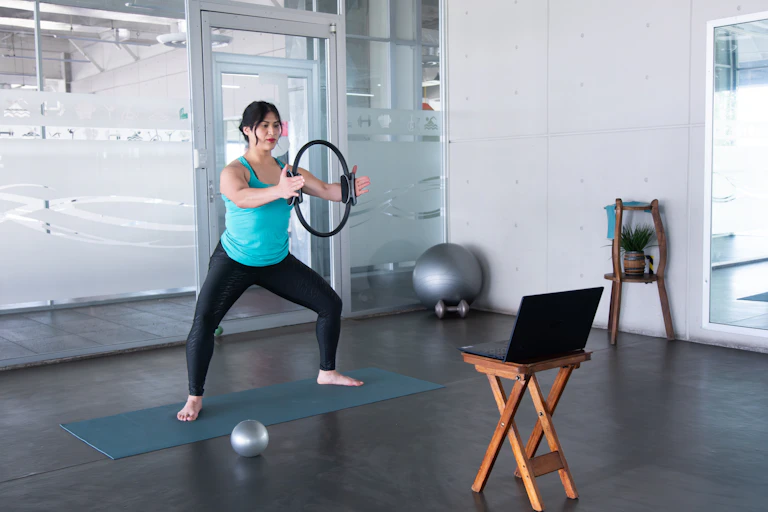 Une femme pratiquant des exercices de gym devant son ordi.