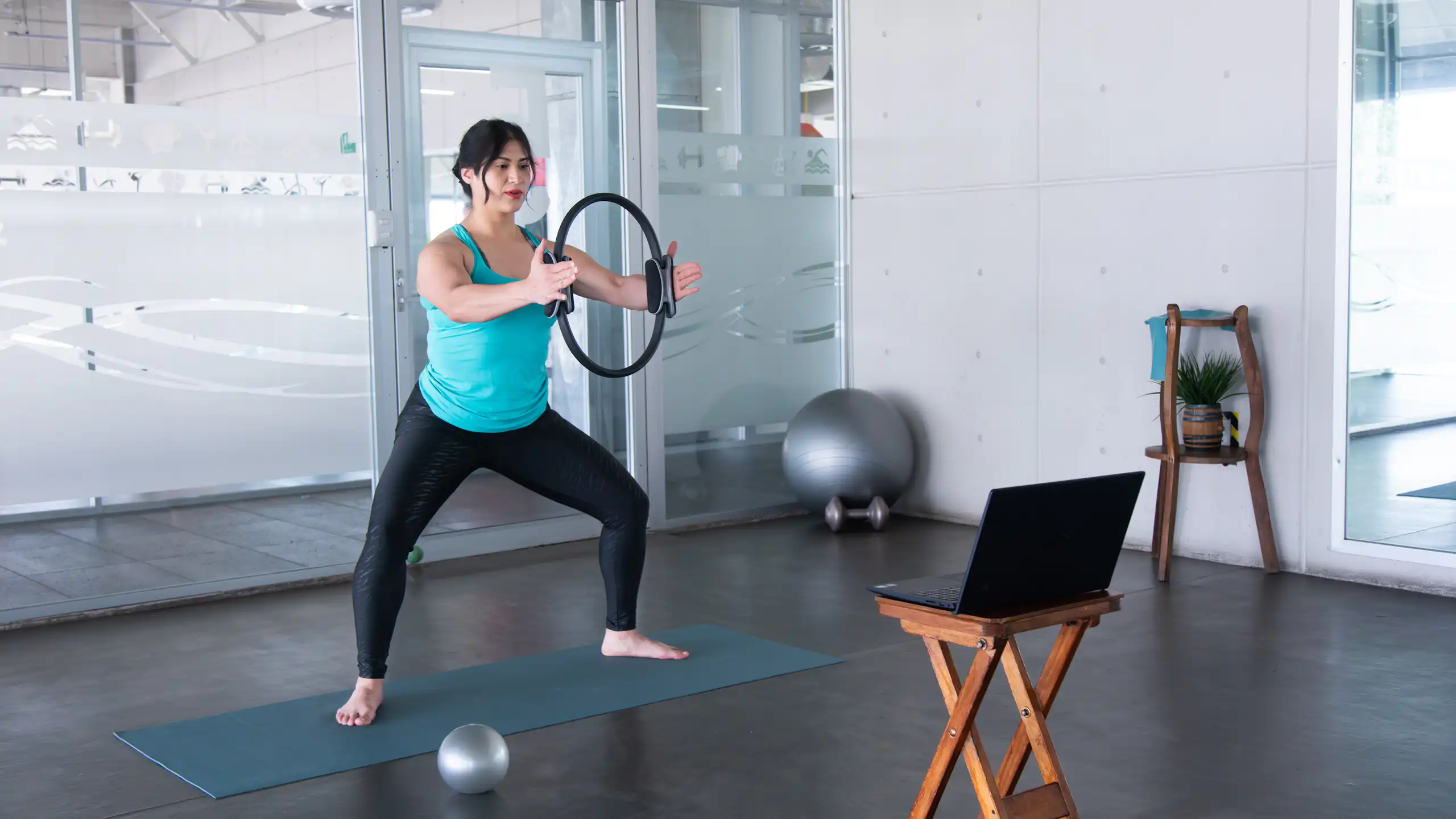 Une femme pratiquant des exercices de gym devant son ordi.