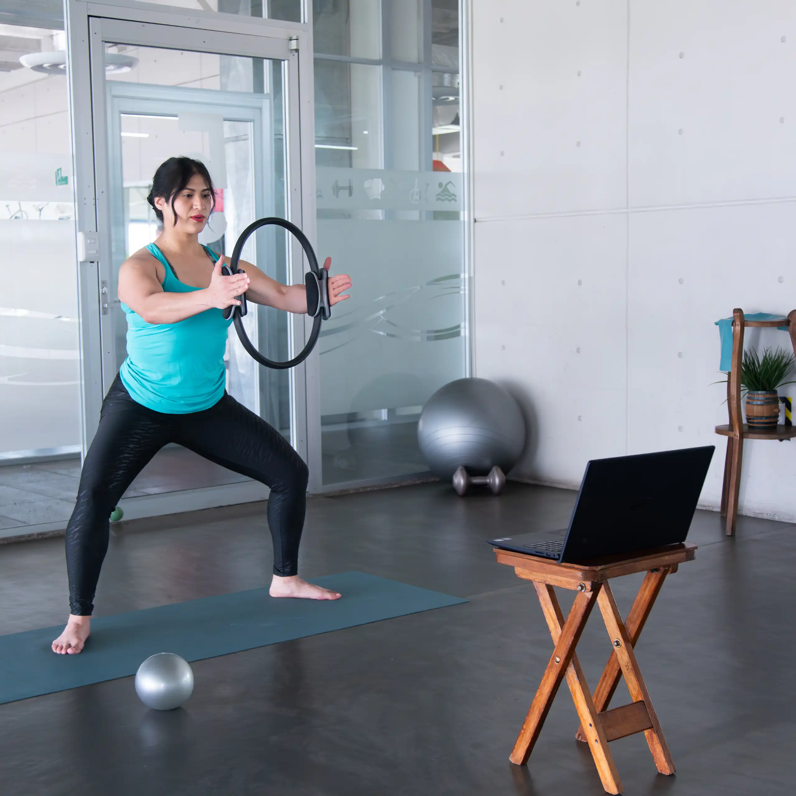 Une femme pratiquant des exercices de gym devant son ordi.