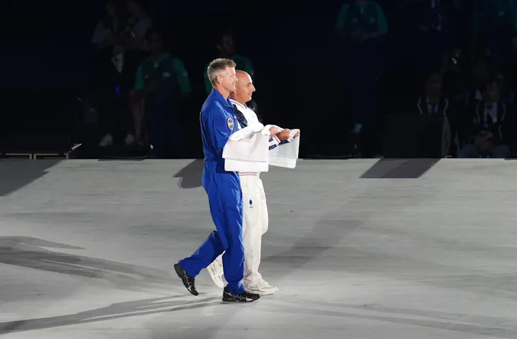John McFall (in blue) carries the Paralympic flag at the opening ceremony of the Paris 2024 Paralympic Games.